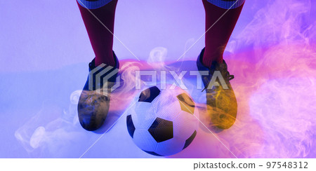 Low section of african american male player with ball standing on smoky background 97548312