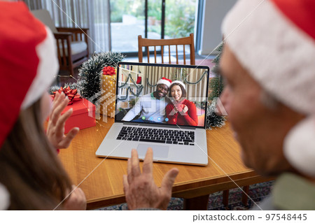 Caucasian father and daughter having christmas video call with diverse couple Caucasian father and daughter having christmas video call with diverse couple 97548445
