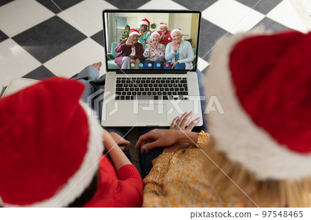 Diverse mother and daughter with santa hats having video call with happy senior diverse friends Diverse mother and daughter with santa hats having video call with happy senior diverse friends 97548465