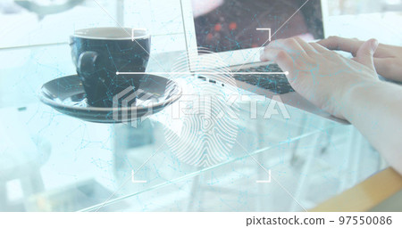 A woman using a laptop with a coffee cup on a table in a restaurant A woman using a laptop with a coffee cup on a table in a restaurant 97550086