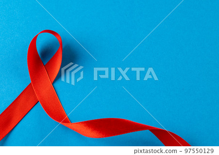 Composition of red ribbon on blue background Composition of red ribbon on blue background 97550129