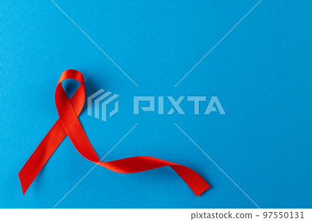 Composition of red ribbon on blue background Composition of red ribbon on blue background 97550131