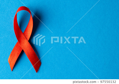 Composition of red ribbon on blue background Composition of red ribbon on blue background 97550132