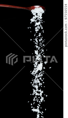 Salt fall, crystal white grain peanuts explode abstract cloud fly from wooden spoon. Beautiful complete seed salt, food object design. Selective focus freeze shot black background isolated 97550554