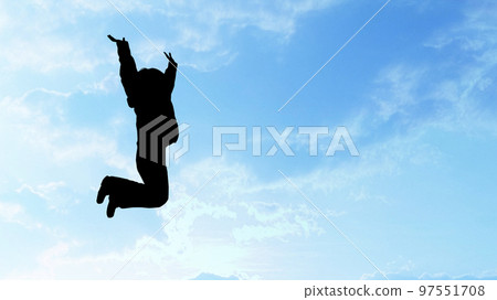 Silhouette of a woman jumping in the blue sky _ wide 97551708