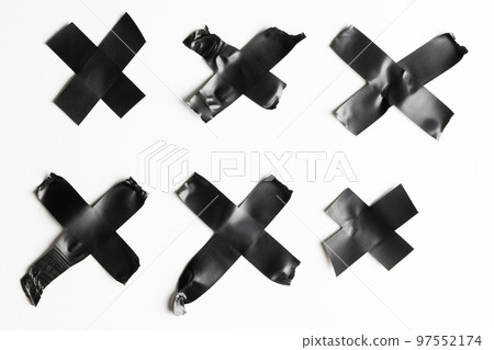 Cross shape black masking tape on white background Cross shape black masking tape on white background 97552174