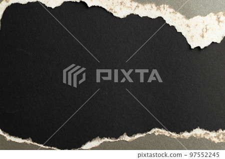 Ripped up piece of gray paper with copy space on black background 97552245