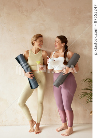 Smiling Woman Talking After Yoga. Female Friends Laughing Holding Detox Drinks 97553247
