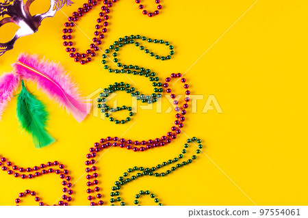 Composition of colourful mardi gras beads, mask and feathers on yellow background with copy space 97554061