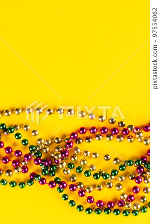 Composition of colourful mardi gras beads on yellow background with copy space Composition of colourful mardi gras beads on yellow background with copy space 97554062