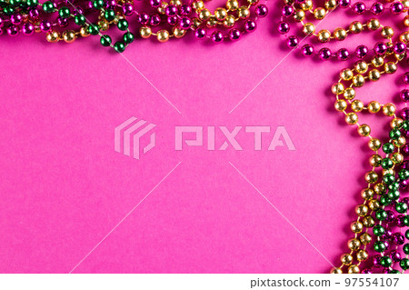 Composition of colourful mardi gras beads on pink background with copy space Composition of colourful mardi gras beads on pink background with copy space 97554107