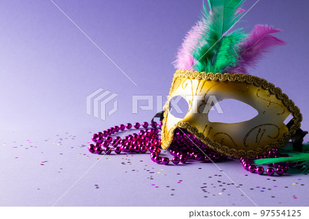 Composition of pink mardi gras beads and carnival mask on blue background with copy space Composition of pink mardi gras beads and carnival mask on blue background with copy space 97554125