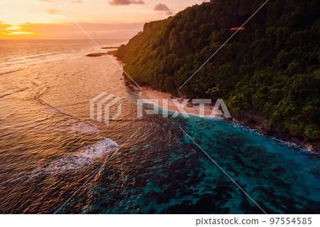 Beautiful coastline with beach and bright warm sunset in Bali. Aerial view Beautiful coastline with beach and bright warm sunset in Bali. Aerial view 97554585