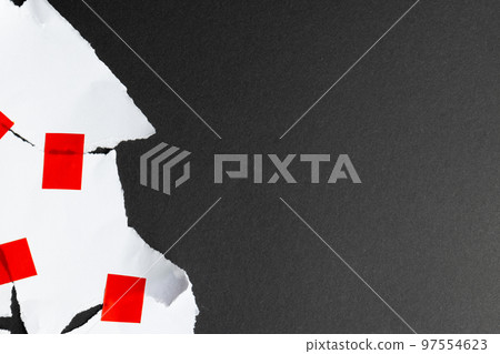 Ripped up pieces of white paper stuck together with red tape with copy space on black background 97554623
