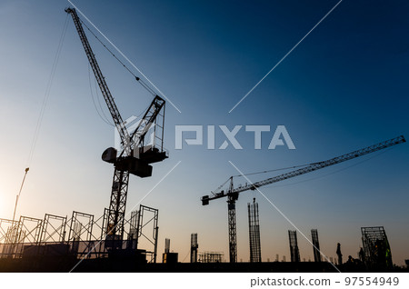 Silhouettes of two cranes against the sky Silhouettes of two cranes against the sky 97554949