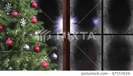 Image of window with snow and christmas tree, and fireworks in night sky 97557639