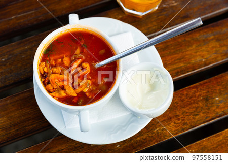 Ceramic bowl with hodgepodge on a wooden table 97558151