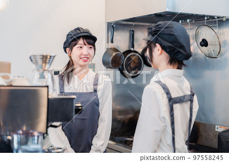 A woman working part-time at a restaurant having fun learning about her work 97558245