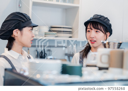 A woman working part-time at a restaurant having fun learning about her work A woman working part-time at a restaurant having fun learning about her work 97558268