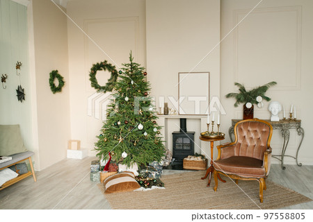 Cozy Christmas interior of the living room with a fireplace and a Christmas tree, an armchair and decor for the New Year 97558805
