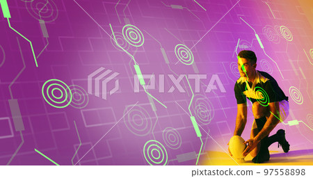 Caucasian rugby player placing ball on stand over illuminated circles and grid pattern Caucasian rugby player placing ball on stand over illuminated circles and grid pattern 97558898
