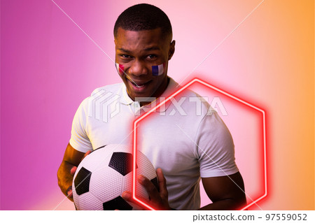 Hexagon neon over african american fan cheering with france flag on cheek during soccer match Hexagon neon over african american fan cheering with france flag on cheek during soccer match 97559052
