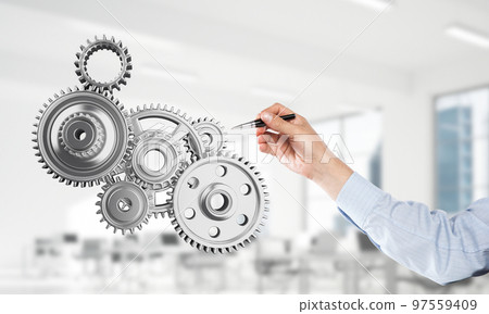 Engine mechanism in male hands as symbol for cooperation or teamworking. Mixed media Engine mechanism in male hands as symbol for cooperation or teamworking. Mixed media 97559409