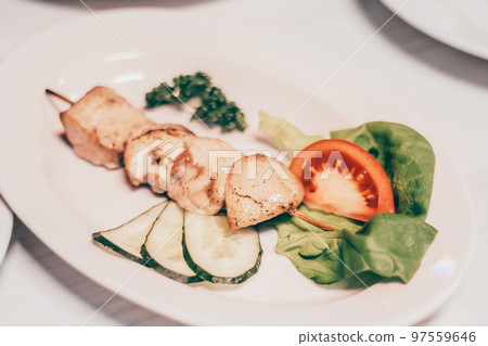 kebab on a wooden skewer and other dishes for a family dinner in the restaurant kebab on a wooden skewer and other dishes for a family dinner in the restaurant 97559646