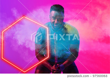 African american male tennis player with racket bending by illuminated hexagon on smoky background African american male tennis player with racket bending by illuminated hexagon on smoky background 97560068