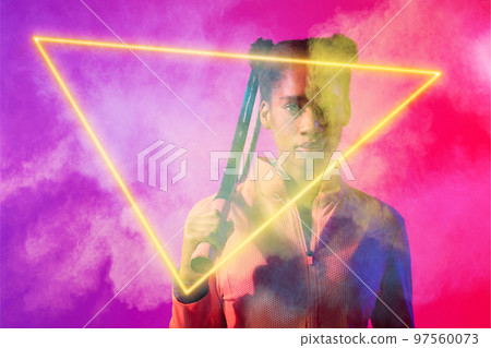 African american female tennis player with racket by illuminated triangle on smoky background 97560073