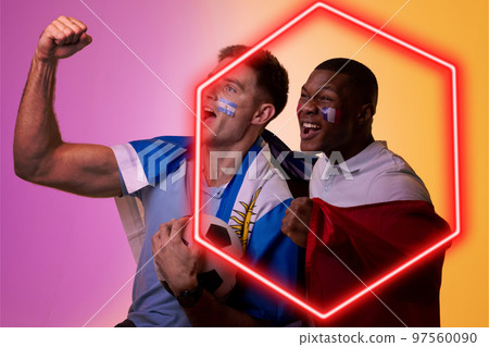 Diverse male fans cheering with argentina and france flags and face paints by illuminated hexagon 97560090