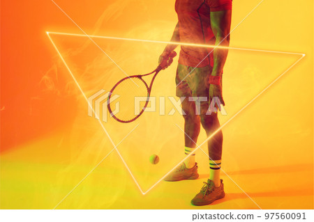 Low section of african american male tennis player with racket and ball by illuminated triangle 97560091