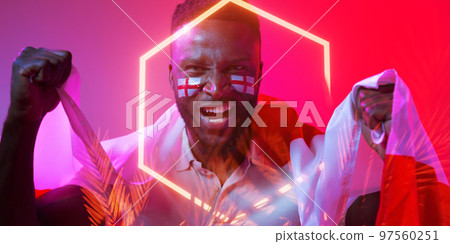 African american male fan with england flag and face paint screaming by hexagon and plants 97560251