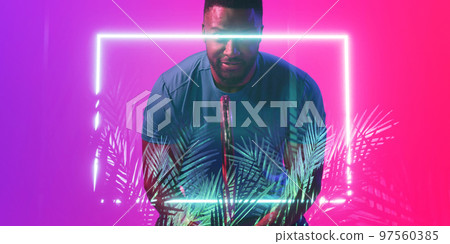 Illuminated plants and rectangle over african american male tennis player holding racket 97560385