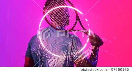 Illuminated plants and circle over rear view of african american male tennis player holding racket 97560386