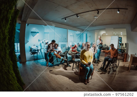 Businesswoman in wheelchair having business meeting with team at modern office. A group of young freelancers agree on new online business projects 97561202