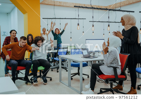 Team building and office fun. Young cheerful businesspeople in smart casual wear having fun while racing on office chairs and smiling. Team building and office fun. Young cheerful businesspeople in smart casual wear having fun while racing on office chairs and smiling. 97561212