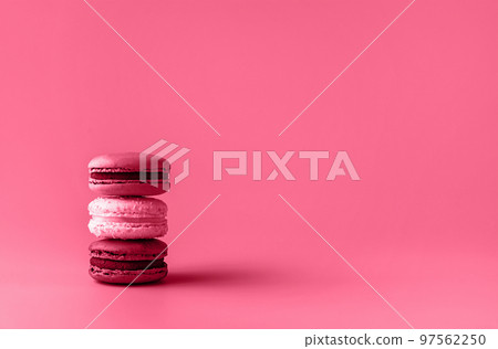 Three macaroons in stack toned in trendy magenta color of year 2023. Food concept. Copy space. Close-up. 97562250
