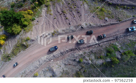 Aerial drone view of ATV quads on a dirt trail in forests. Off-road group team club enthusiasts having fun while driving countryside roads.  97562259