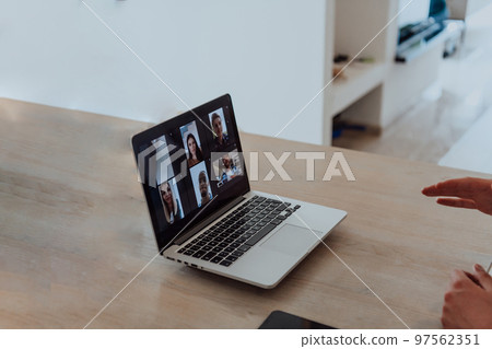 Photo of a laptop with modern headphones on a wooden table in a house with a modern interior 97562351