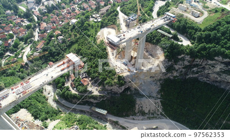 Aerial drone view on highway bridge road under construction. Construction of the viaduct on the modern new road. 97562353