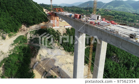 Aerial drone view on highway bridge road under construction. Construction of the viaduct on the modern new road. 97562354