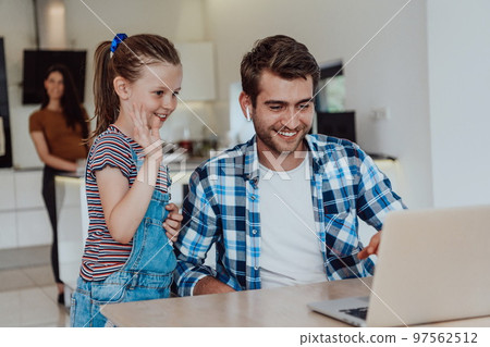 Father and daughter in modern house talking together on laptop with their family during holidays. The life of a modern family Father and daughter in modern house talking together on laptop with their family during holidays. The life of a modern family 97562512