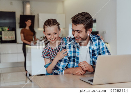 Father and daughter in modern house talking together on laptop with their family during holidays. The life of a modern family 97562514