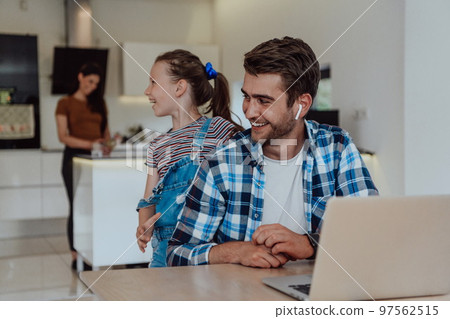 Father and daughter in modern house talking together on laptop with their family during holidays. The life of a modern family 97562515