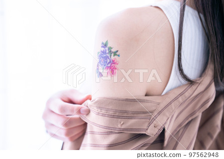 A woman with a tattoo on her arm [parts cut] 97562948