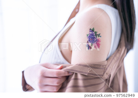 A woman with a tattoo on her arm [parts cut] 97562949