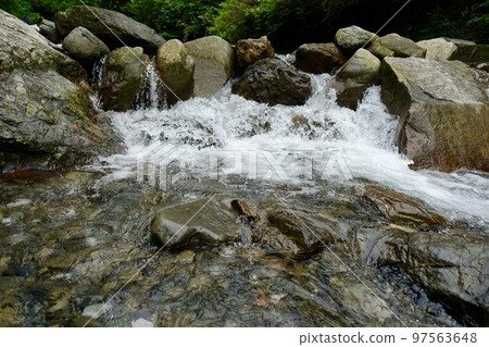 Water splash on rocky mountain stream 97563648