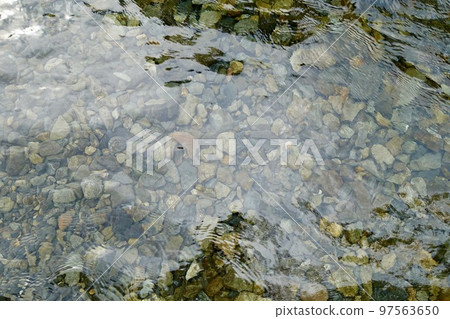 Pebbles visible on the transparent riverbed 97563650