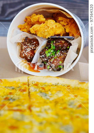 cheese pizza and caramelized chicken, meat strips in paper bucket  97564320